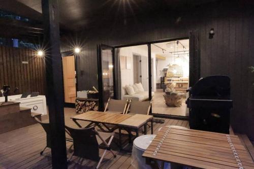 a living room with a table and a piano at SAUNA FOREST CABIN 軽井沢 御代田 A棟 zen-asobi in Oiwake