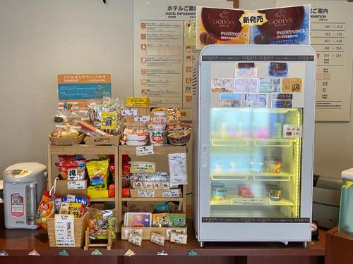 a refrigerator sitting on top of a table with food at Paradis Inn Sagamihara in Sagamihara