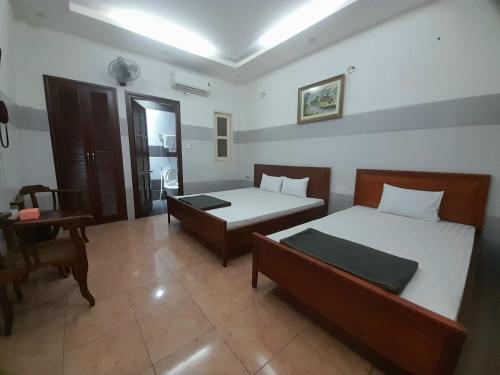 een slaapkamer met 2 bedden en een bureau. bij An An Hotel in Ho Chi Minh-stad