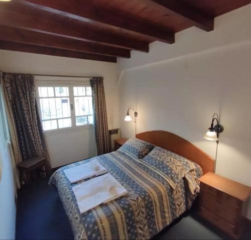 een slaapkamer met een bed en een raam bij Casa de descanso in San Martín de los Andes