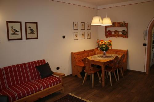 un soggiorno con tavolo e divano di Casa Basilio a Predazzo