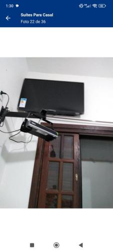 a flat screen tv sitting on top of a desk at Suítes Para Casal in Bertioga