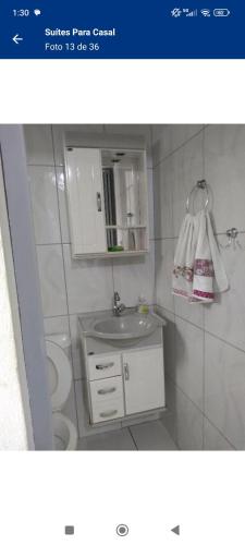 a bathroom with a sink and a toilet at Suítes Para Casal in Bertioga