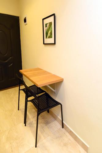 a table and a chair next to a wall at Solmi Rooms in Calero