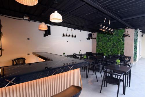 a restaurant with black tables and chairs and plants at Solmi Rooms in Calero