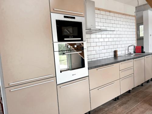a kitchen with white cabinets and a microwave at Ubytování JANOVKA in Žár
