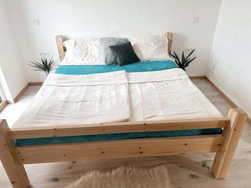 a bed with a wooden frame in a bedroom at Ubytování JANOVKA in Žár