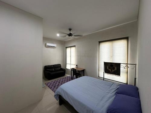a bedroom with a bed and a chair in it at Balqish House in Seremban