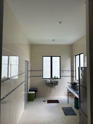 a large bathroom with a sink and a shower at Balqish House in Seremban