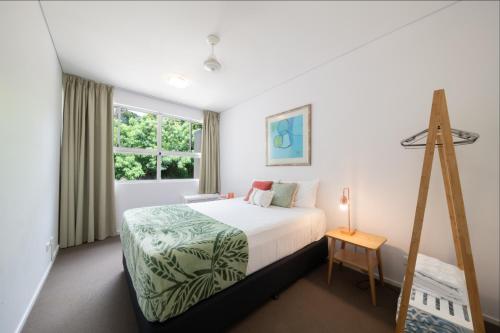 a bedroom with a bed and a window at Azure Sea Whitsunday Resort in Airlie Beach