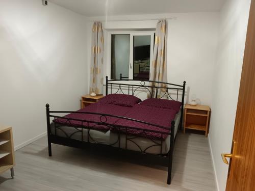 a bedroom with a black bed with a purple blanket at Wirtin z Atzersdorf 