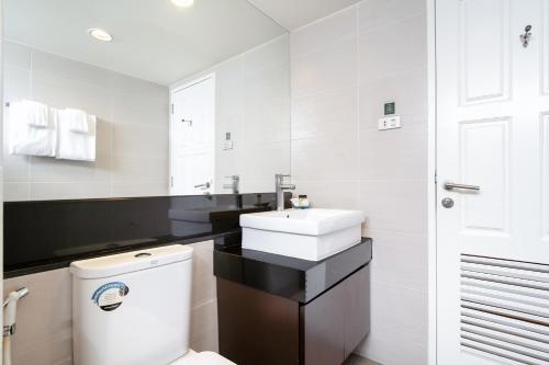 a bathroom with a white toilet and a sink at Lily Hotel Bangkok in Bangkok