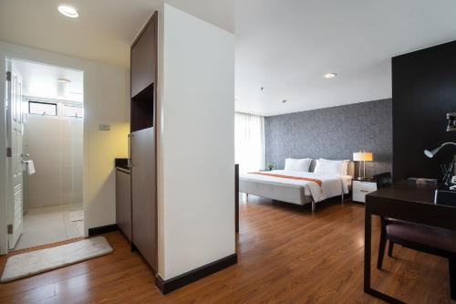 a hotel room with a bed and a desk at Lily Hotel Bangkok in Bangkok