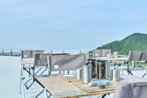 a table on a boat with tables and chairs at Snow Peak YAKEI SUITE ABURAYAMA FUKUOKA in Fukuoka