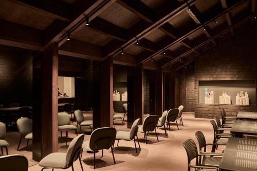 a dining room with chairs and tables and a brick wall at Snow Peak YAKEI SUITE ABURAYAMA FUKUOKA in Fukuoka