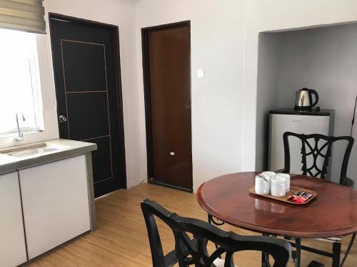a kitchen with a table and chairs and a kitchen with a refrigerator at Zaque's Hotel in Sungai Petani