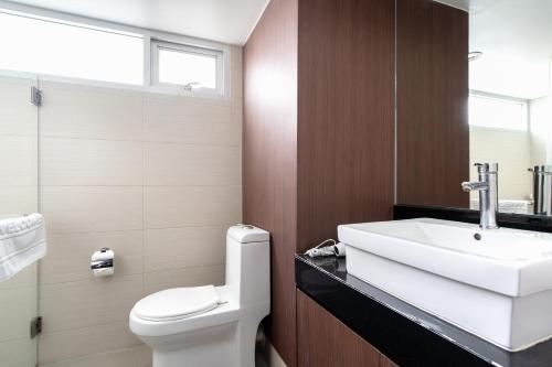 a bathroom with a white toilet and a sink at Lily Hotel Bangkok in Bangkok