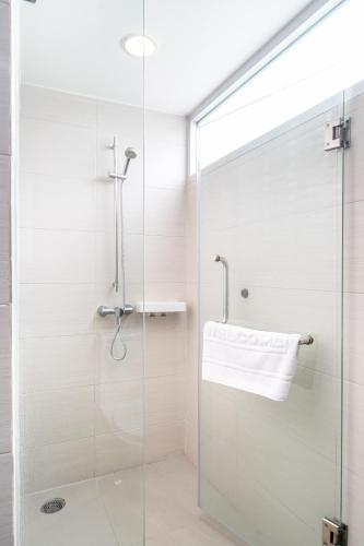 a shower with a glass door in a bathroom at Lily Hotel Bangkok in Bangkok