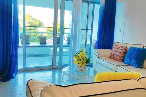 a living room with a couch and a glass table at tropicana sur apt221 in Sosúa