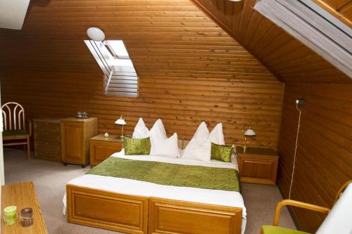 een slaapkamer met een bed in een houten kamer bij Hotel Molnár in Boedapest