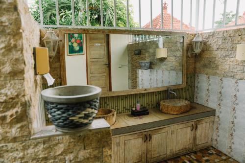 a bathroom with a large mirror and a sink at Taman Asih Bingin Homestay in Uluwatu