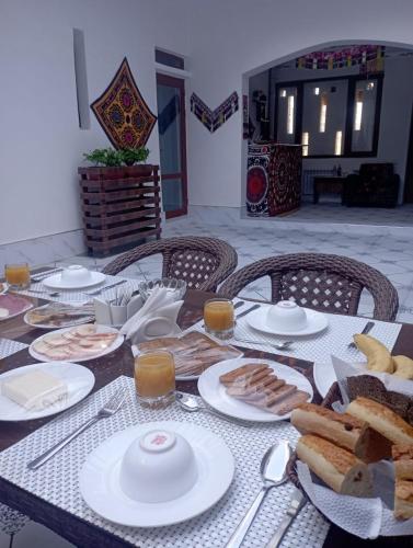 een tafel met borden eten en brood erop bij Art Suzani in Bukhara