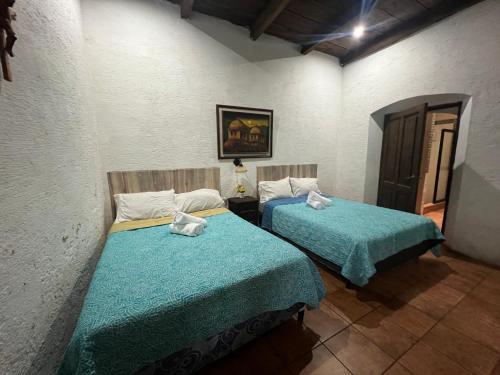 a room with two beds in a room at Casa del viajero colonial in Antigua Guatemala