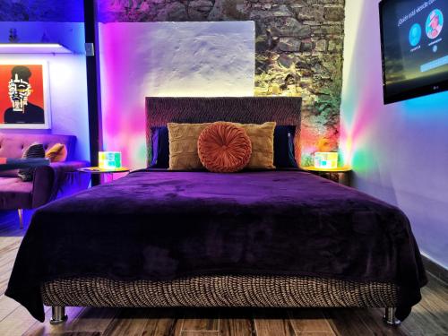um quarto com uma cama com lençóis roxos e luzes em Space Oddity By Paradox na Cidade do Panamá