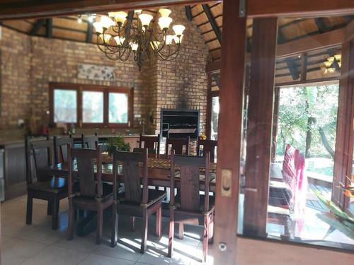 a dining room with a wooden table and chairs at Dreamy 3 bedroom villa on the edge of the Sabie River in Kruger Park Lodge in Hazyview