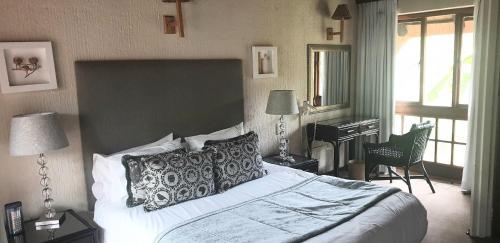 哈玆維尤的住宿－Dreamy 3 bedroom villa on the edge of the Sabie River in Kruger Park Lodge，一间卧室配有一张大床和一架钢琴