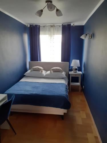 1 Schlafzimmer mit blauen Wänden und 1 Bett mit 2 Kissen in der Unterkunft GREEN AP Nalkowskich in Lublin