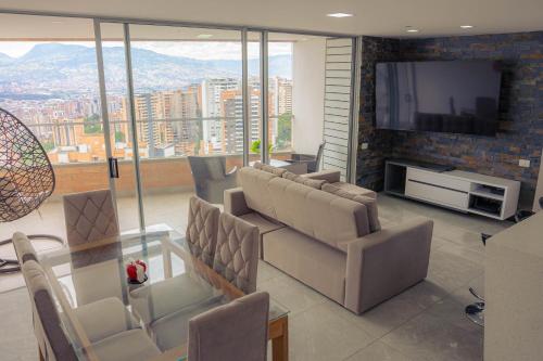 uma sala de estar com sofás e uma televisão de ecrã plano em Medellin Luxury PH 22-Floor Incredible City View em Envigado