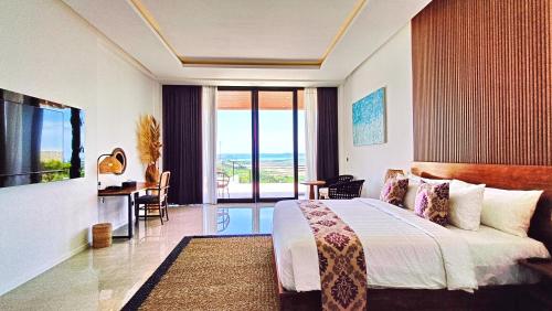 a bedroom with a bed and a view of the ocean at VILLA VALITO in Kuta Lombok