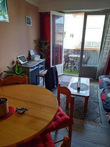- un salon avec une table en bois, une table et des chaises dans l'établissement Argeles Plage, à Argelès-sur-Mer