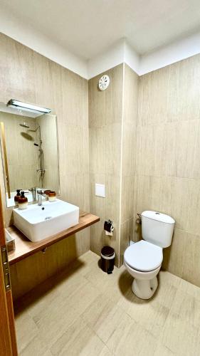 a bathroom with a white toilet and a sink at Boutique House Blue Lagoon by Flat Mаnаger in Balchik