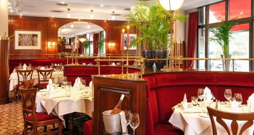 Victor's Residenz-Hotel Saarbrücken في ساربروكن: غرفة طعام مع طاولات وكراسي في مطعم