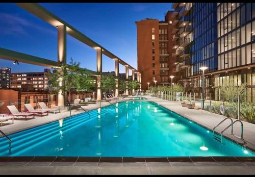 a large swimming pool with chairs and a building at High Rise 3 Bedroom Sleeps 9 Walk to Cripto Arena in 20 Minutes in Los Angeles