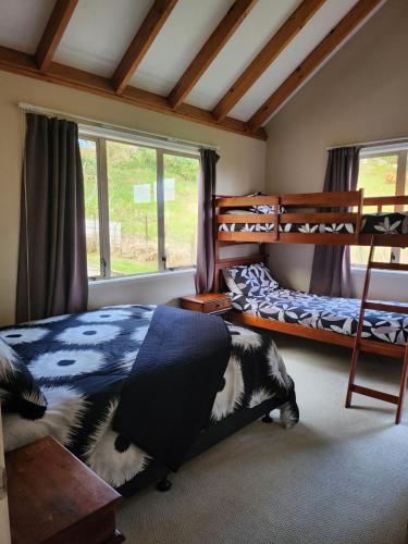 - une chambre avec 2 lits superposés et une fenêtre dans l'établissement Whangarei Holiday Houses, à Whangarei