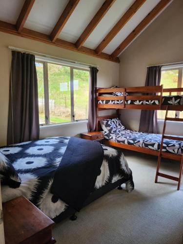 a bedroom with two bunk beds and a window at Whangarei Holiday Houses in Whangarei