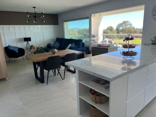 a kitchen and living room with a table and a couch at Casa del Golf in Alcaidesa