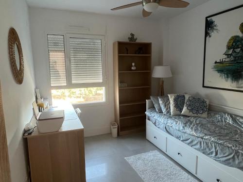 a bedroom with a bed and a desk and a window at Casa del Golf in La Alcaidesa