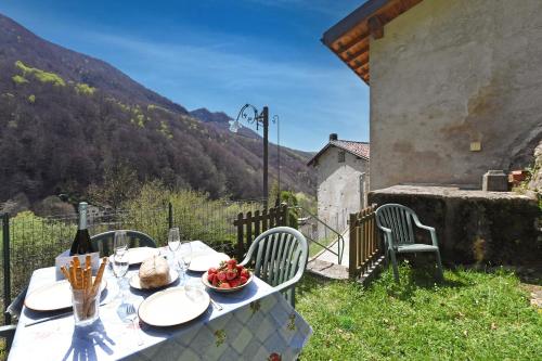 a table with a bowl of fruit and a bottle of wine at Casa Lara - Happy Rentals in Lugano