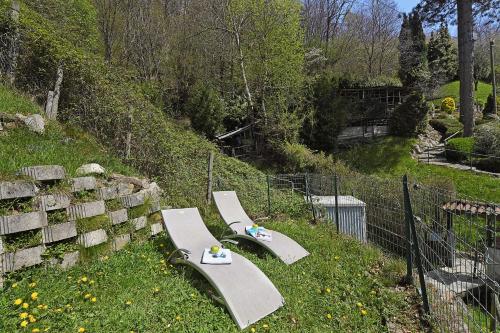 two lounge chairs sitting in the grass next to a fence at Casa Lara - Happy Rentals in Lugano