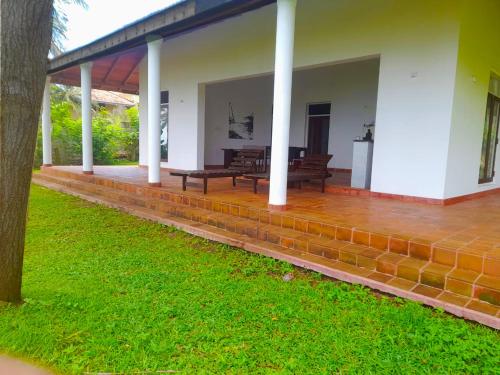 a porch of a house with benches on it at Bluewind Resort in Tangalle
