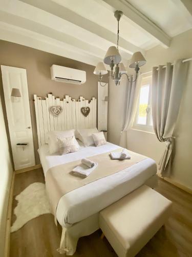 une chambre blanche avec un grand lit et une fenêtre dans l'établissement Le Petit Nid de Beauval, à Saint-Aignan