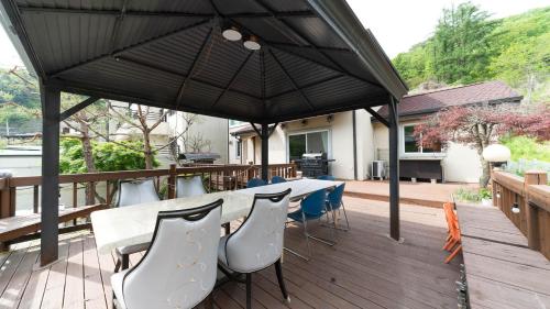 a patio with a table and chairs under a black umbrella at Amuse 545 in Yangpyeong
