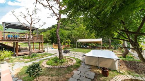 a large white tub in a yard with a deck at Amuse 545 in Yangpyeong