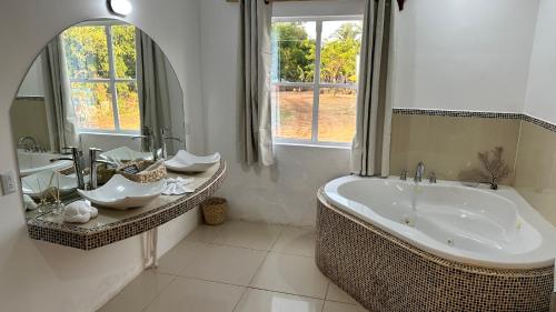 a bathroom with a large tub and two sinks at Emerald Luxe Suites in Big Corn Island
