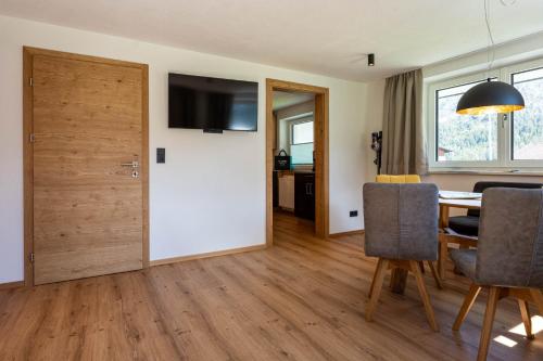 a room with a white door and a table with chairs at Maurig Appartements in Elbigenalp