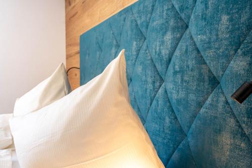 a bedroom with a bed with a blue wall at Maurig Appartements in Elbigenalp